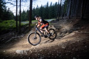 Frau mit E-Mountainbike in der Abfahrt